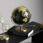 Globe terrestre rotatif noir et doré sur pied doré